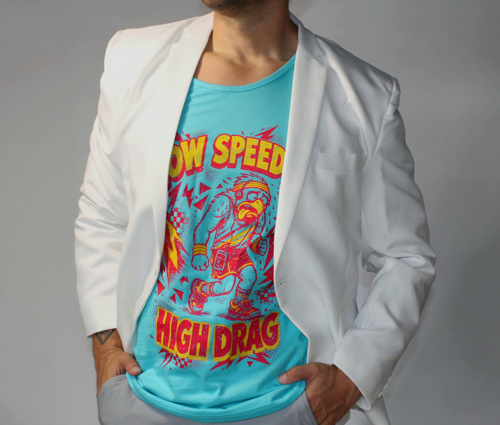 A man wearing a white blazer over a bright turquoise graphic t-shirt with a retro cartoon character and the words 'LOW SPEED HIGH DRAG'.